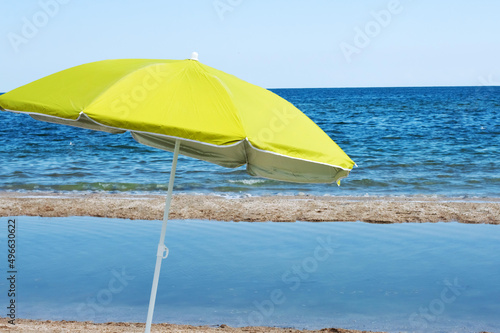 Blurred image of a sun umbrella on a sea beach without people. © Iryna