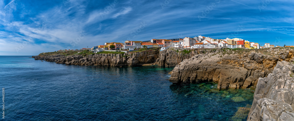 panorama view of the jagged rocky coast and colorful houses in the center of Peniche