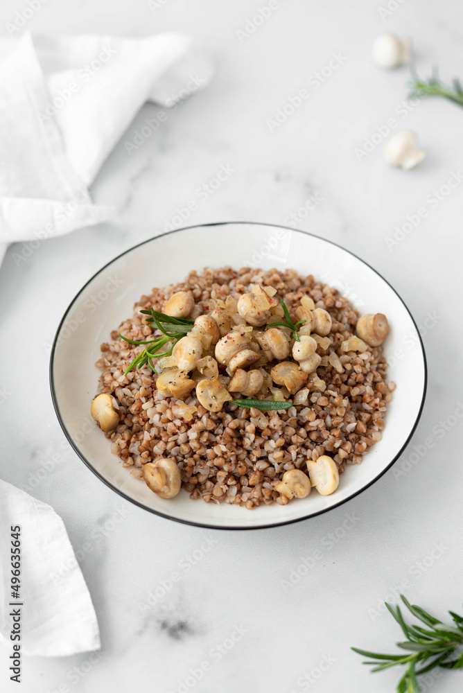 buckwheat porridge with fried mushrooms and onions and parsley in a white bowl buckwheat porridge with fried mushrooms and onions and parsley in a white bowl