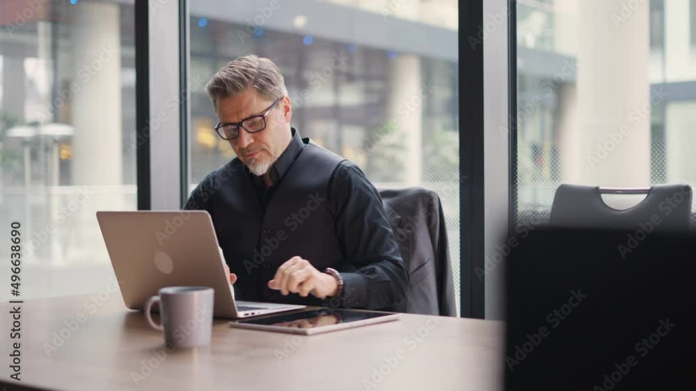 Businessman using laptop computer in office. Happy middle aged man, entrepreneur, small business owner working online. Businessman using laptop computer in office. Happy middle aged man, entrepreneur, small business owner working online.