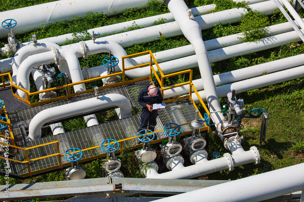 Top view male worker inspection at valve of visual check record pipeline oil Top view male worker inspection at valve of visual check record pipeline oil