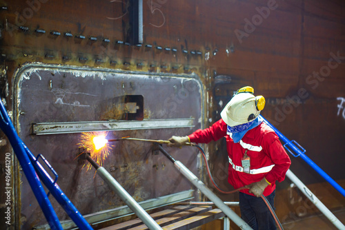 Male worker preheating It involves heating the shell plate metal tank either in its entirety or just the region surrounding plate steel photo