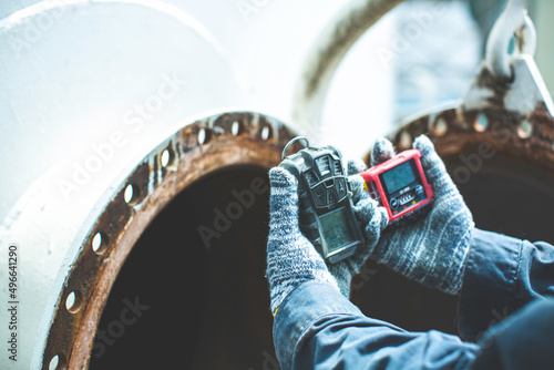 Fotografi Worker hand holding gas detector inspection safety gas testing at front manhole