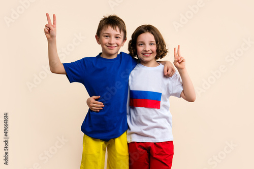Boy and Girl in basic outfits in colors flags Russian Federation and Ukraine Hug and Show Sign Hands Gesture Peace. Concept successful truce negotiations. Friendship Fraternal Peoples photo