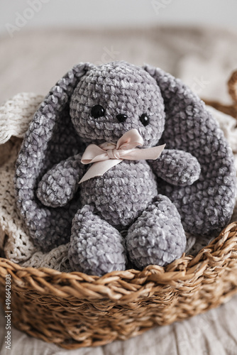 Knitted bunny of gray color in the interior of a bright apartment