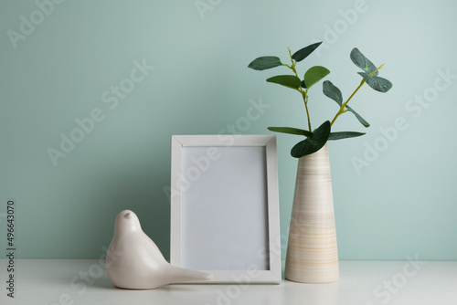 Wallpaper Mural Cozy home desk table with vase with green branch, ceramic bird and photo frame. Torontodigital.ca