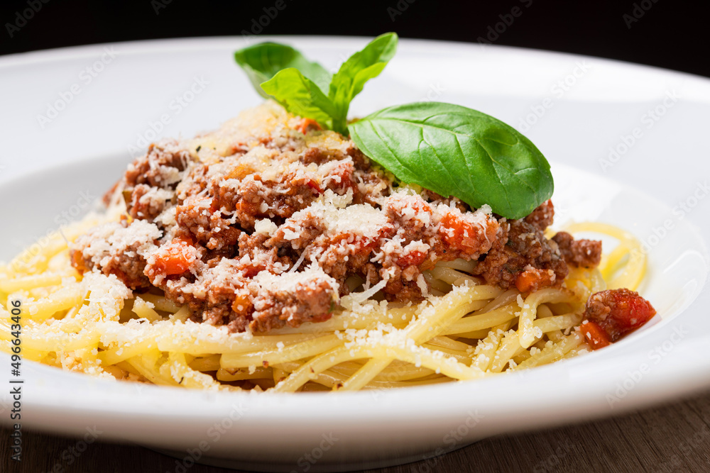 tasty pasta bolognese with basil and cheese on white plate tasty pasta bolognese with basil and cheese on white plate