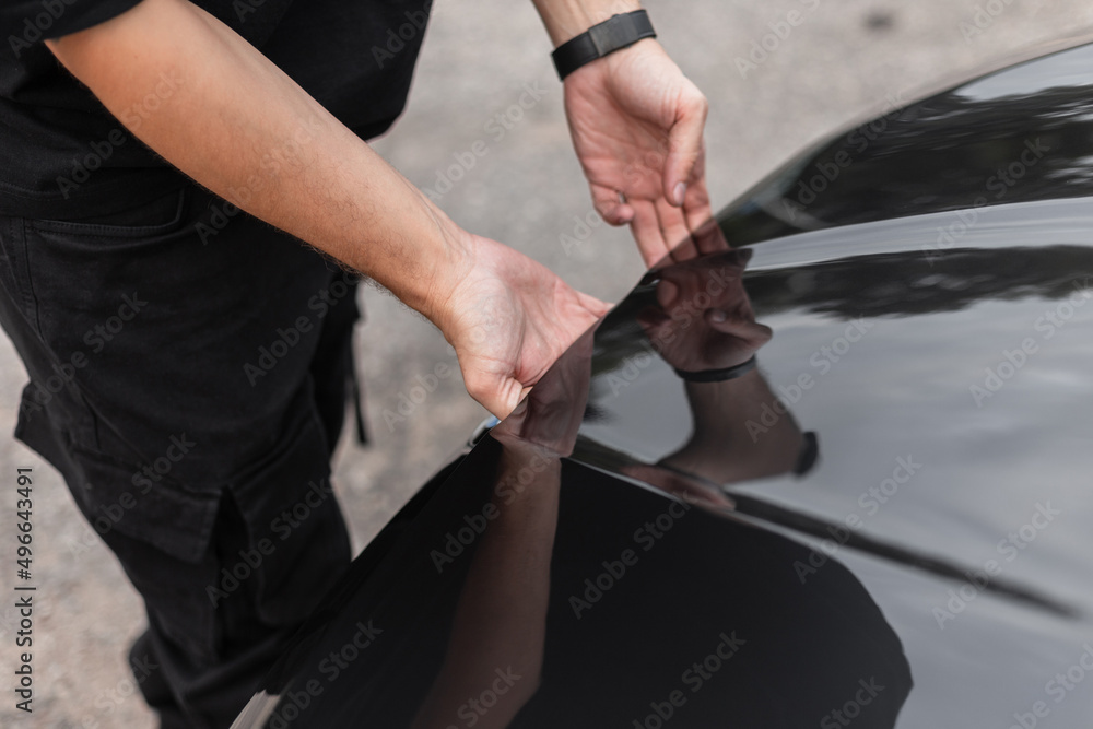 Man's hands open the hood of the car. Professional car mechanic guy starts to work, concept