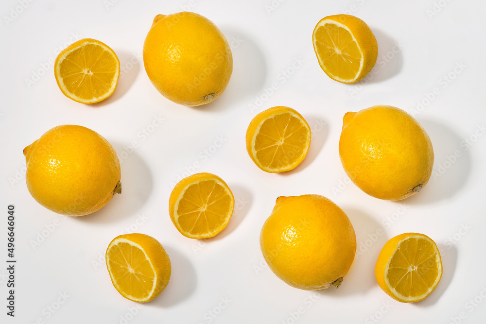 Lemon with halves and whole ripe lemons on white background