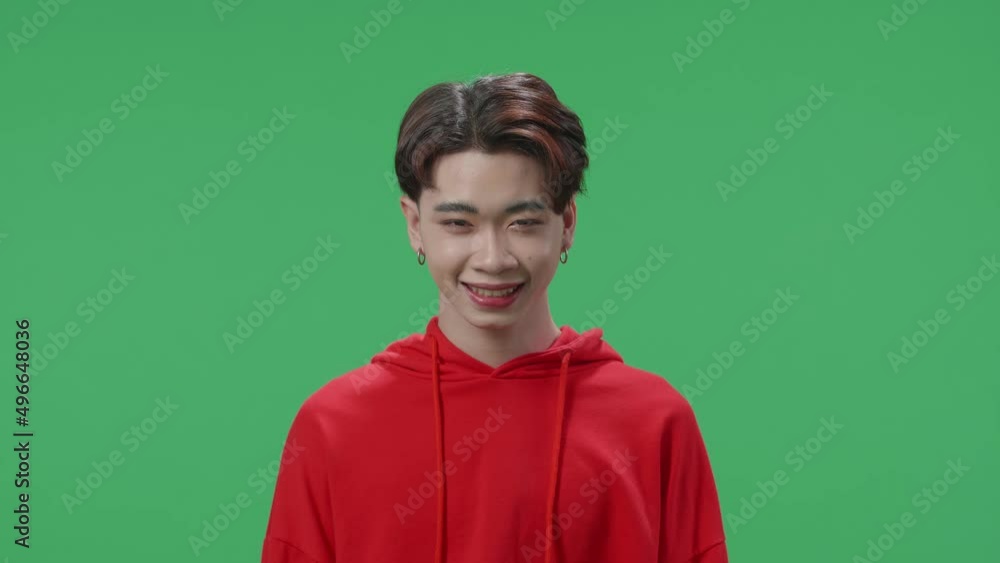 The Portrait Of A Smiling Asian Transgender Male Positively Shaking Her Head At The Camera In The Green Screen Studio
