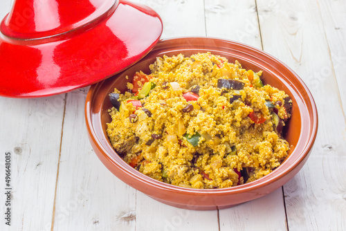Traditionally orepared meal in the moroccan tagine with couscous, vegetables and dried fruit on a white table
