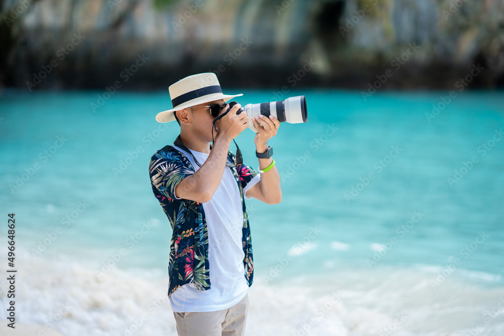 Obraz premium male tourist using a camera Taking pictures of the sea in Thailand