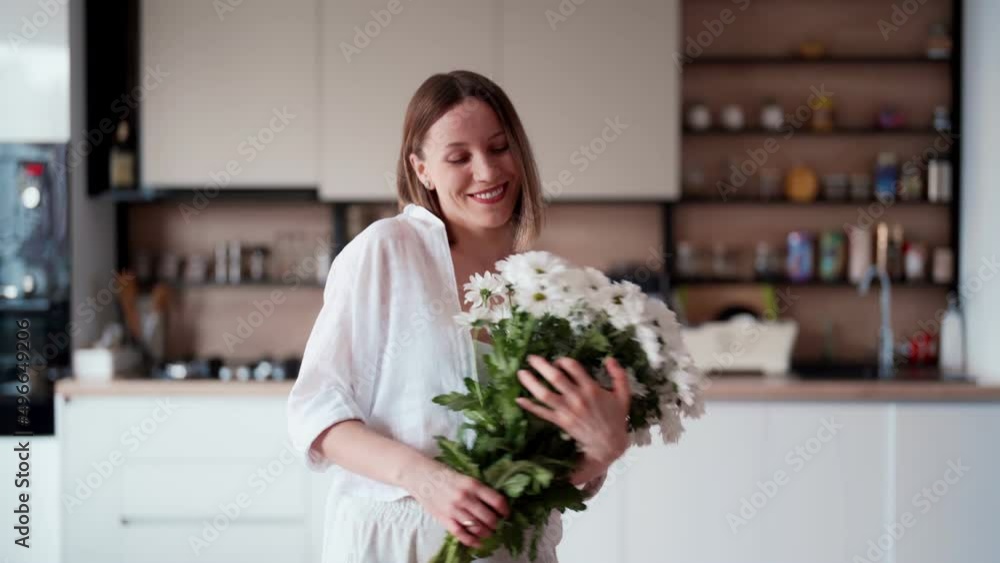 Young beautiful cute sweet lovely smiling woman with hold a bouquet of white fresh flowers at home Young beautiful cute sweet lovely smiling woman with hold a bouquet of white fresh flowers at home