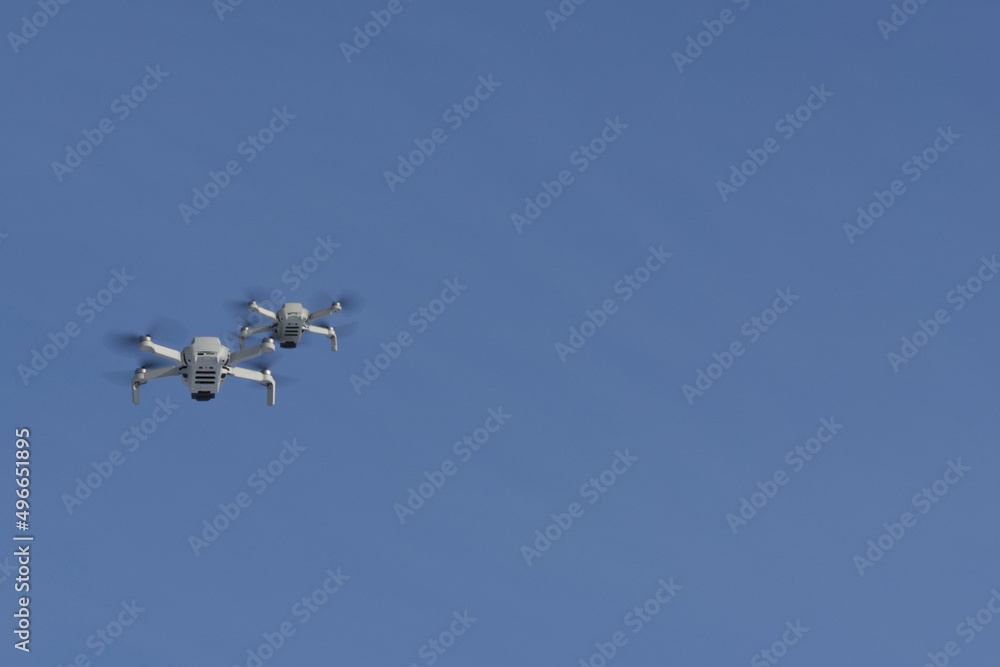 Two modern Remote Control Air Drones Fly with action cameras in blue sky. Modern technologies. Close up. Travel, hobby, inspiration. Two modern Remote Control Air Drones Fly with action cameras in blue sky. Modern technologies. Close up. Travel, hobby, inspiration.