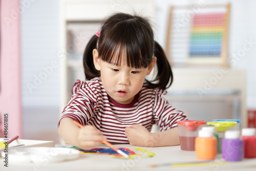 young girl painting handmade craft at home