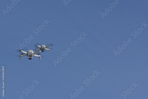 Two modern Remote Control Air Drones Fly with action cameras in blue sky. Modern technologies. Close up. Travel  hobby  inspiration.