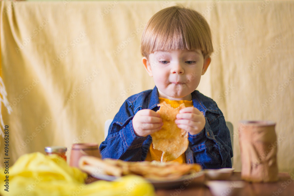 a little boy with a smile eats delicious pancakes with jam
a little boy with a smile eats delicious pancakes with jam