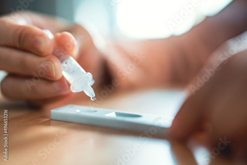 Fotografía Close up of woman swab COVID-19 testing by Rapid Antigen Test kit and dropping r