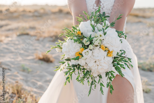 Wedding bouquet in the hands of the bride. Yellow and white flowers