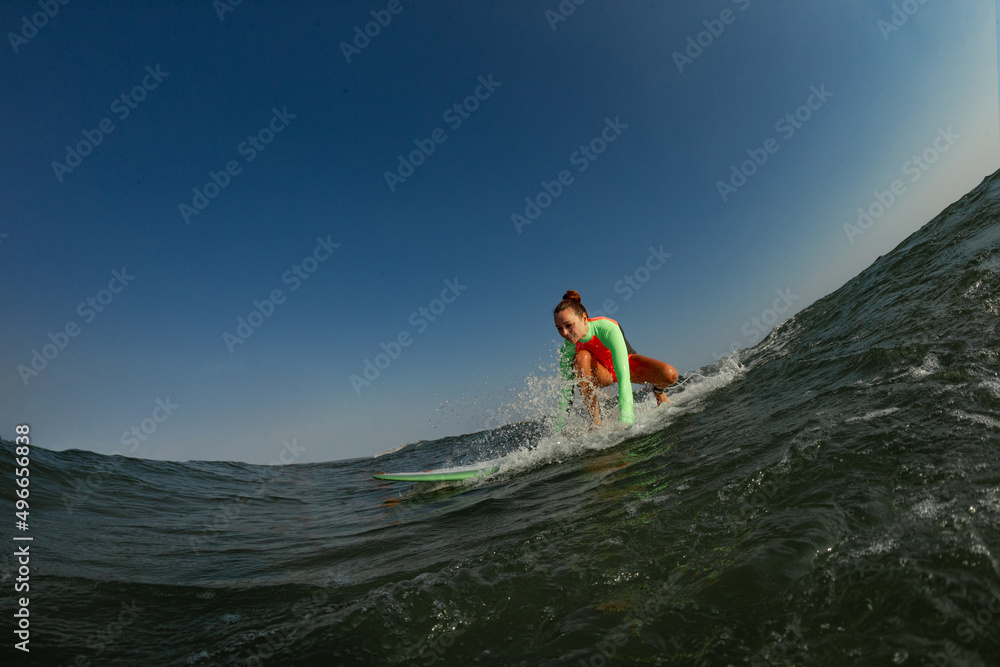  Portrait of a female surfer on her surfboard in the water in action