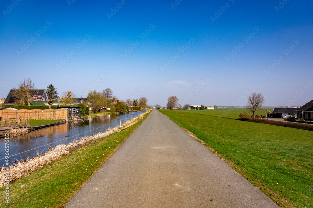 Fototapeta premium Country road by the water channel beautiful view