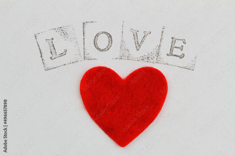 Word love made with letter stamps and big red heart on white background
