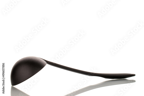 One black silicone kitchen spoon, close-up, isolated on a white background.