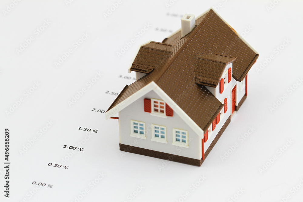 List of interest rates and plastic model house on white background
