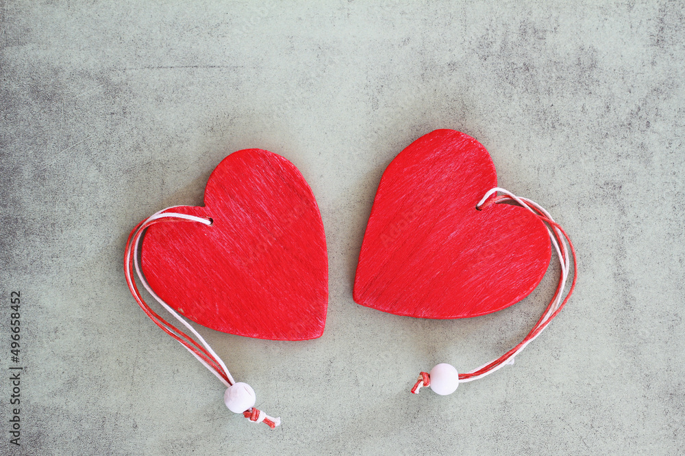 Two red wooden hearts on grey surface with vintage look with copy space
