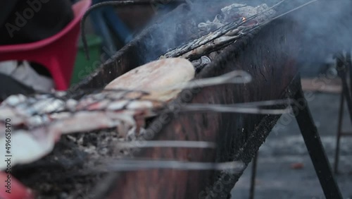  photo of traditional grills for fish inside a Moroccan seaport.lot of smoke