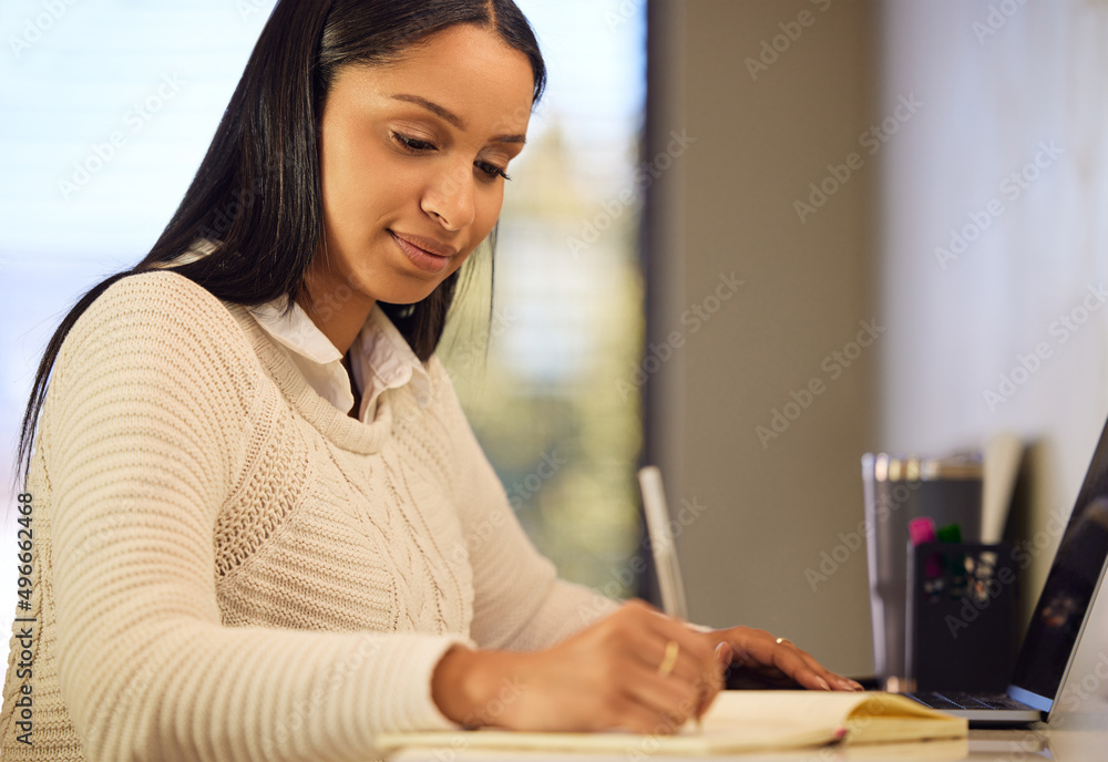 Study notes. Cropped shot of an attractive young woman studying at home. Study notes. Cropped shot of an attractive young woman studying at home.
