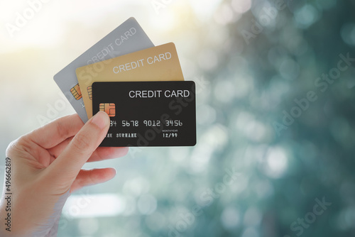 Woman hand holding various credit cards on natural bokeh background. photo