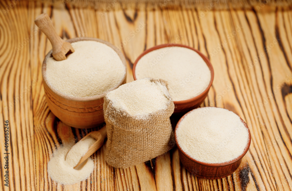 Semolina in bowls and bags on a wooden background. High quality photo Semolina in bowls and bags on a wooden background. High quality photo