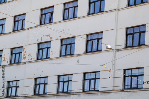 The wall of a multi-storey house is cracked, the plaster is crumbling