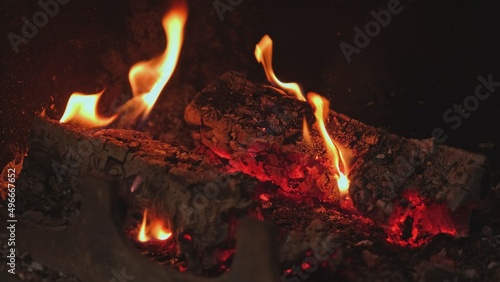 Red Hot Wood Log Embers with Yellow Flames Burning in Fireplace