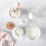 Background for baking cakes and donuts. Baking ingredients - flour, egg, milk, sugar on a white background. Top view