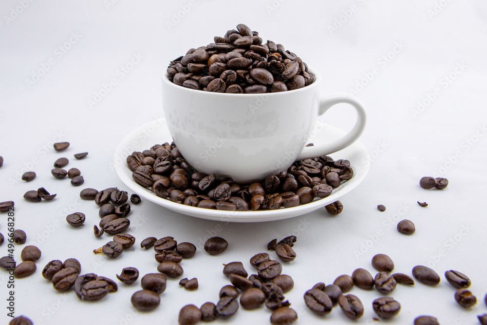 Obraz premium Coffee beans in white coffee cup on white background