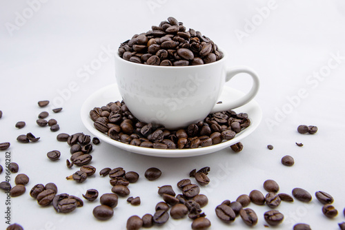 Coffee beans in white coffee cup on white background