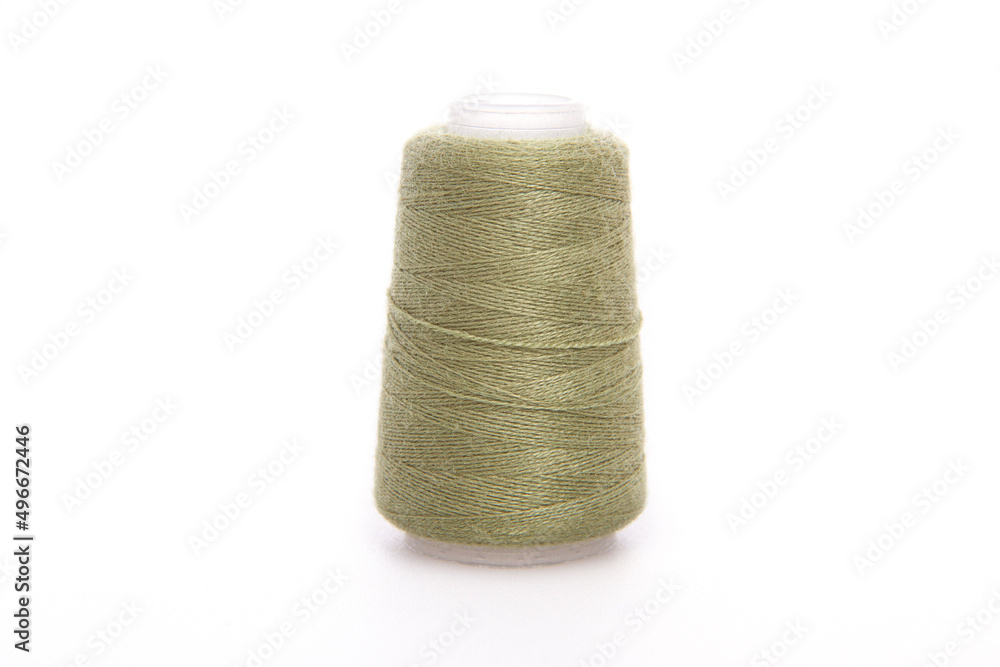 Green spool of thread isolated on white background. Skein of woolen threads. Yarn for knitting. Materials for sewing machine. Coil. Green spool of thread isolated on white background. Skein of woolen threads. Yarn for knitting. Materials for sewing machine. Coil.