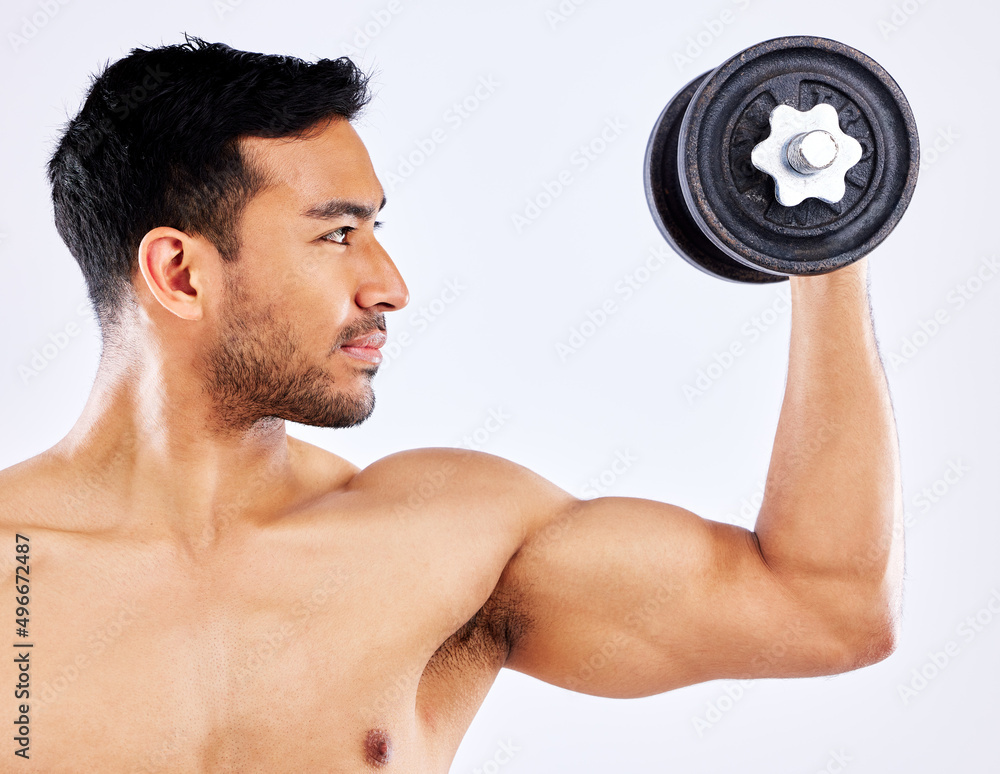 Use high quality equipment. Shot of a young man flexing his bicep muscles while holding a weight against a studio background. Use high quality equipment. Shot of a young man flexing his bicep muscles while holding a weight against a studio background.