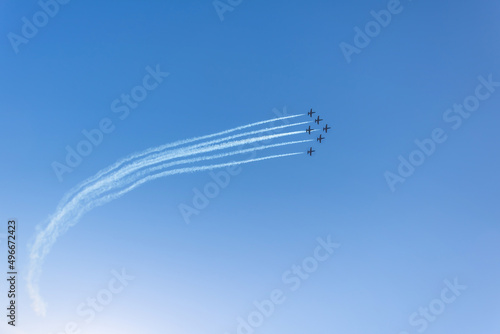Canvas Print Silhouette of an airplane performing acrobatic flight on blue sky