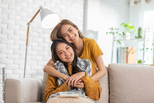 An Asian couple is taking care to their partner. LGBTQ female lasbian give their partner a scarf while the other has reading a book. They are living spending time together.Good moment of LGBTQ photo