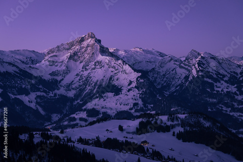 Morgendämmerung über den Bergen der winterlich verschneiten Glarner Alpen in der Schweiz