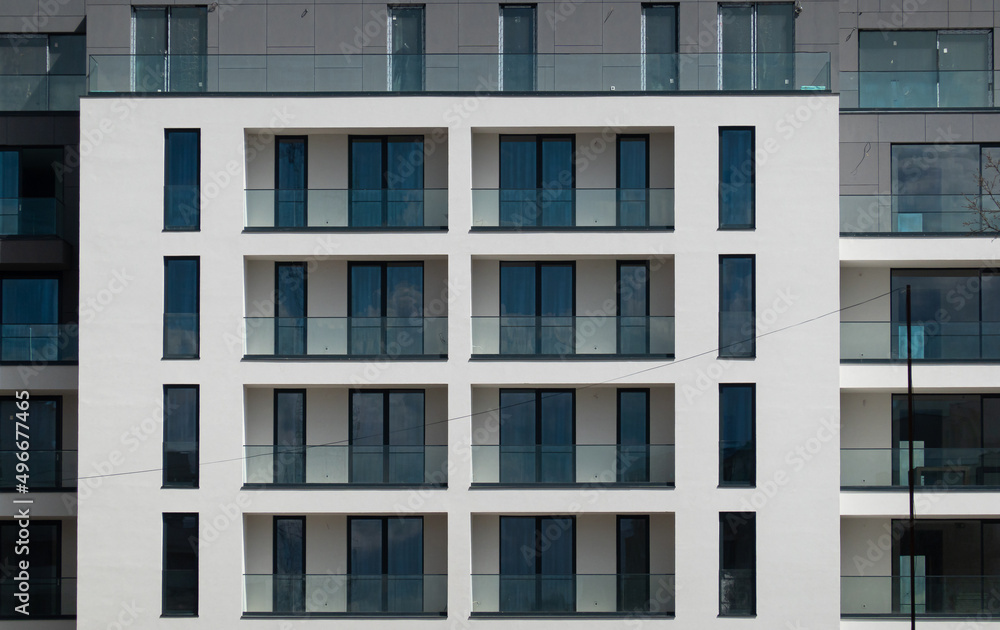 Frontal view of a new residential building after the construction was finished. Premium residential flat buildings industry. Frontal view of a new residential building after the construction was finished. Premium residential flat buildings industry.