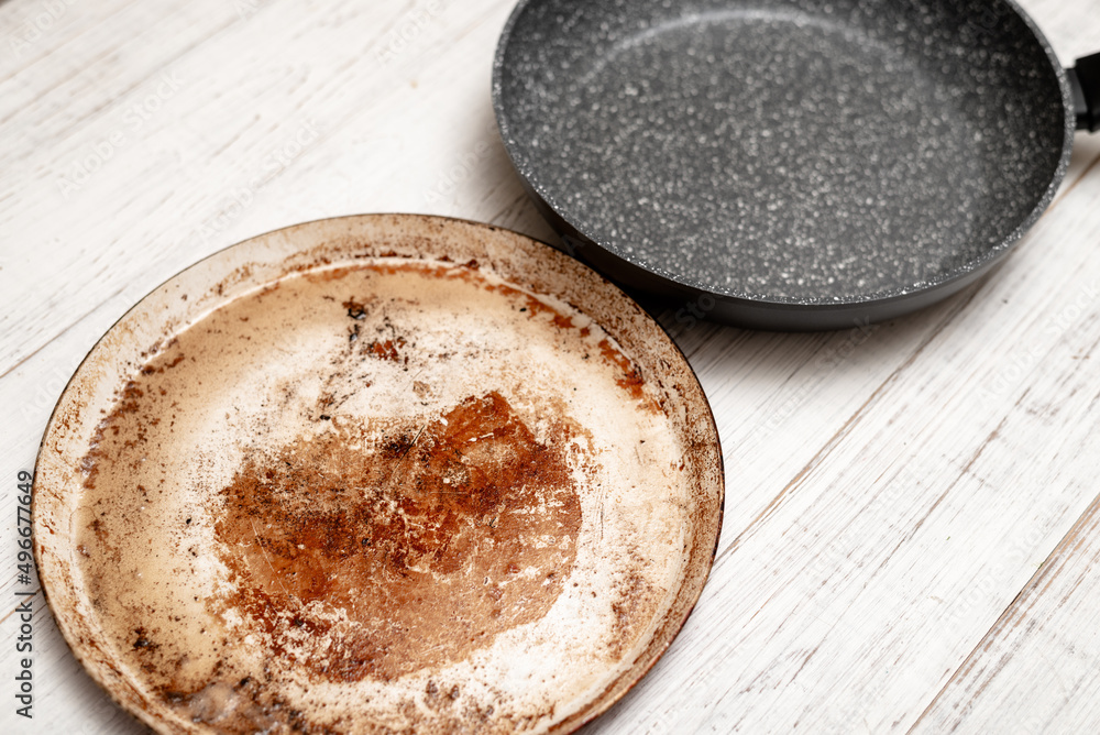 Comparison of pans. Old and new frying pan. New and old damaged non-stick coating. Comparison of pans. Old and new frying pan. New and old damaged non-stick coating.