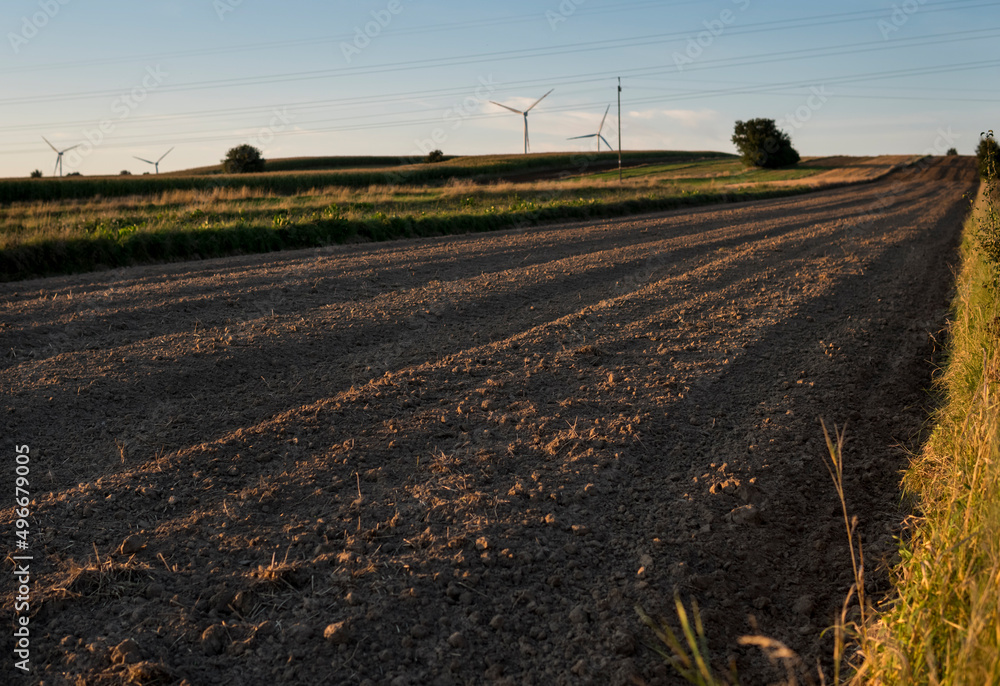 rural landscape with empty fields and wind turbines rural landscape with empty fields and wind turbines