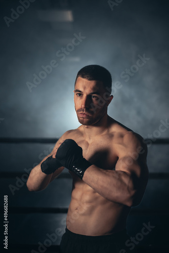 Boxer, man posing in bandage on boxing ring. Fitness and boxing concept. High quality photo © herraez