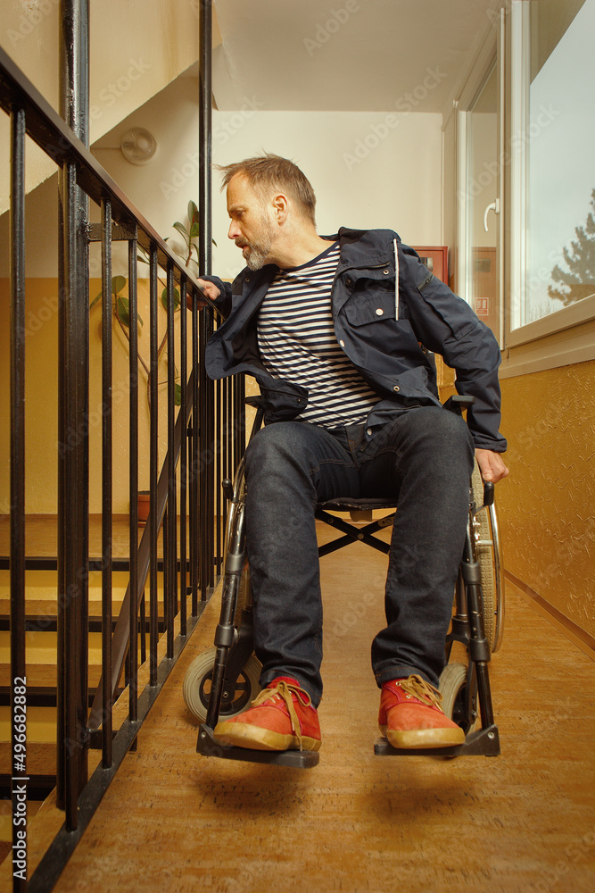 Fototapeta premium Disabled man on wheel chair riding in apartment house corridor