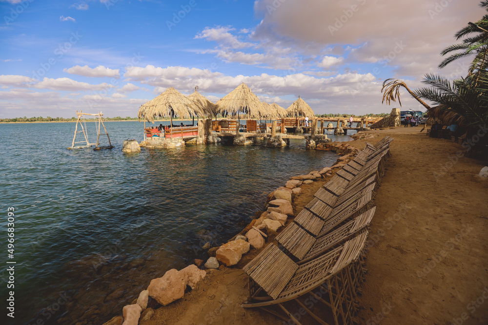 Relaxing Under Palm Trees in the Luxury Restaurant on the Salt Lake Aftanas Coastline near Siwa Oasis, Egypt Relaxing Under Palm Trees in the Luxury Restaurant on the Salt Lake Aftanas Coastline near Siwa Oasis, Egypt