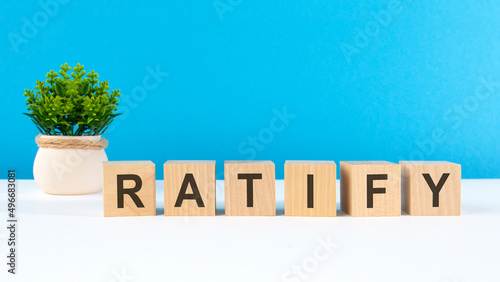 the word ratify is written on wooden cubes on a light blue background photo